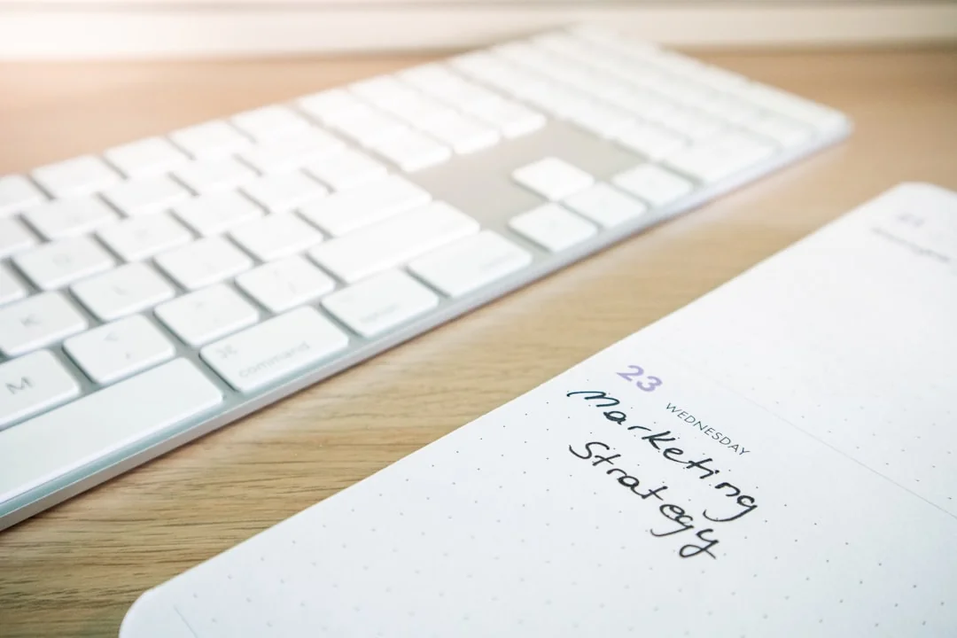 Planner open on a desk with handwritten Holiday Email Marketing Series note.